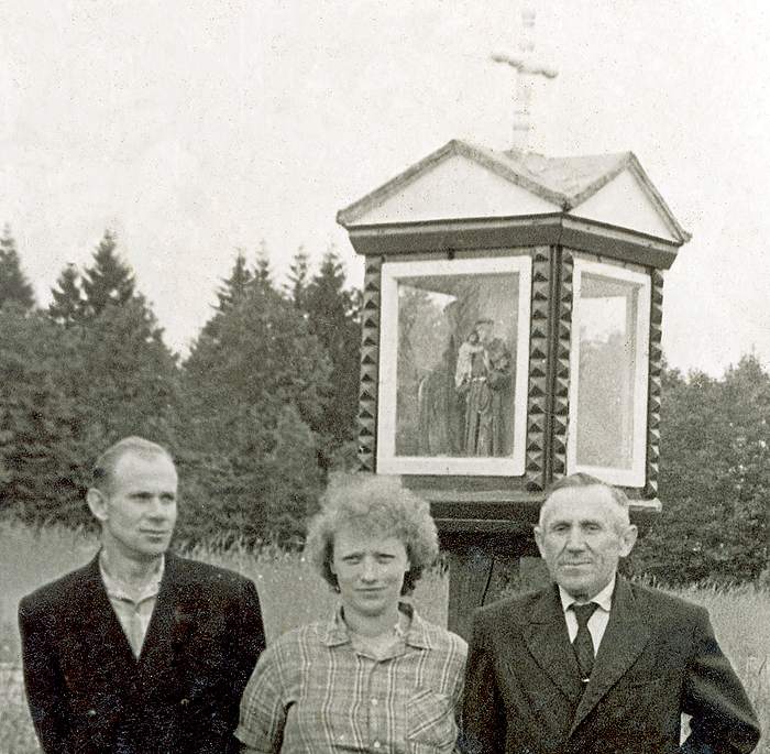 Prie koplytstulpio Girininkuose. Dešinėje stovi Antanas Pakalniškis, buvęs partizanas Senelis. 1958 m. Nuotrauka iš Zuzanos Norkienės rinkinio.
